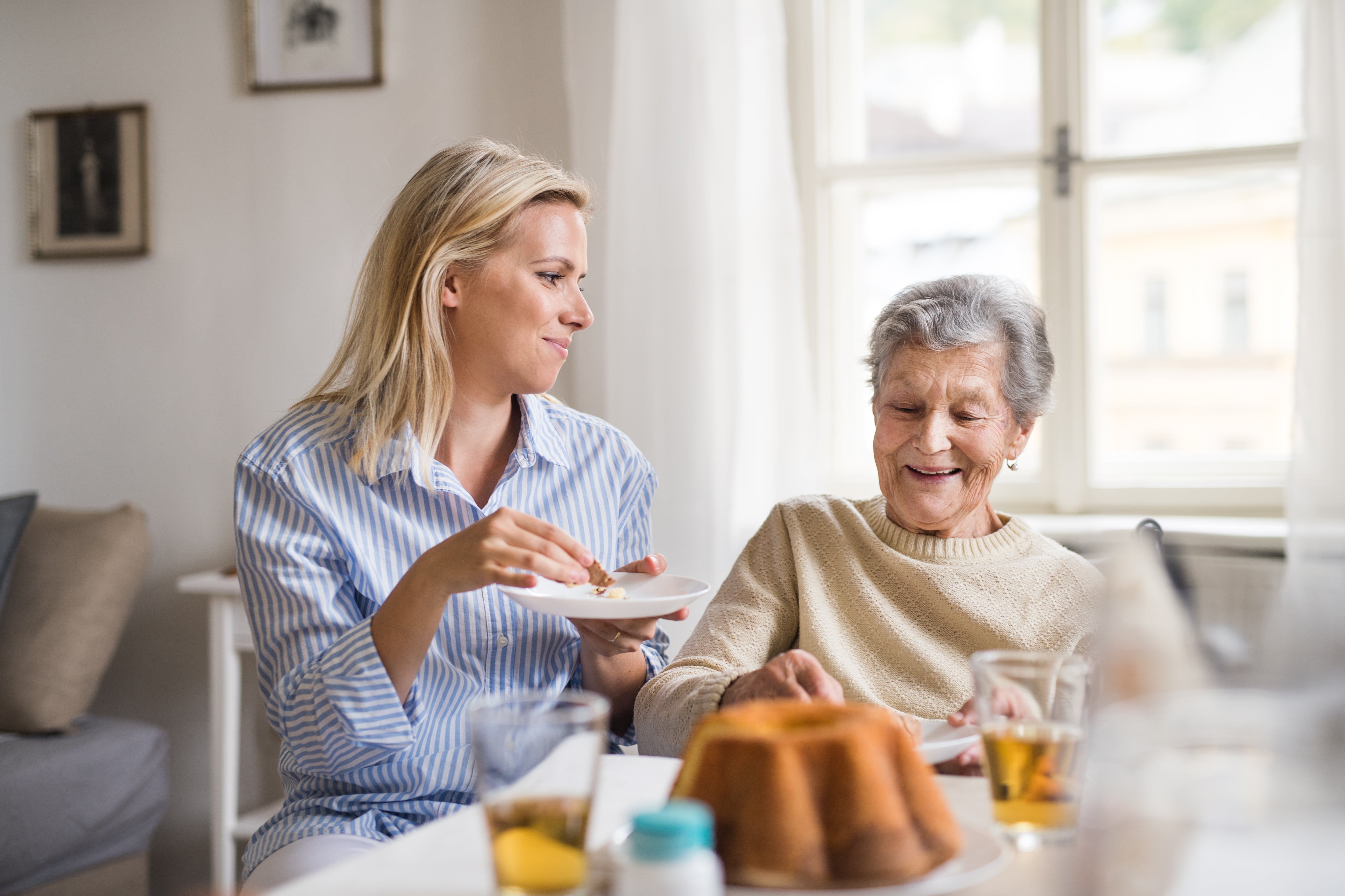 A caregiver helping an older loved one with dementia during mealtime