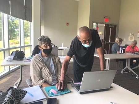 Two older adults participating in the technology training program