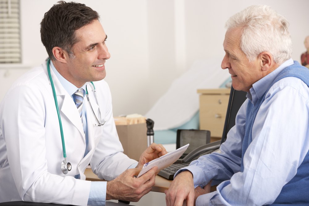 An older adult consulting with his doctor