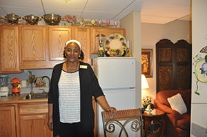 Margaret Wagner Apartments resident standing in kitchen, smiling