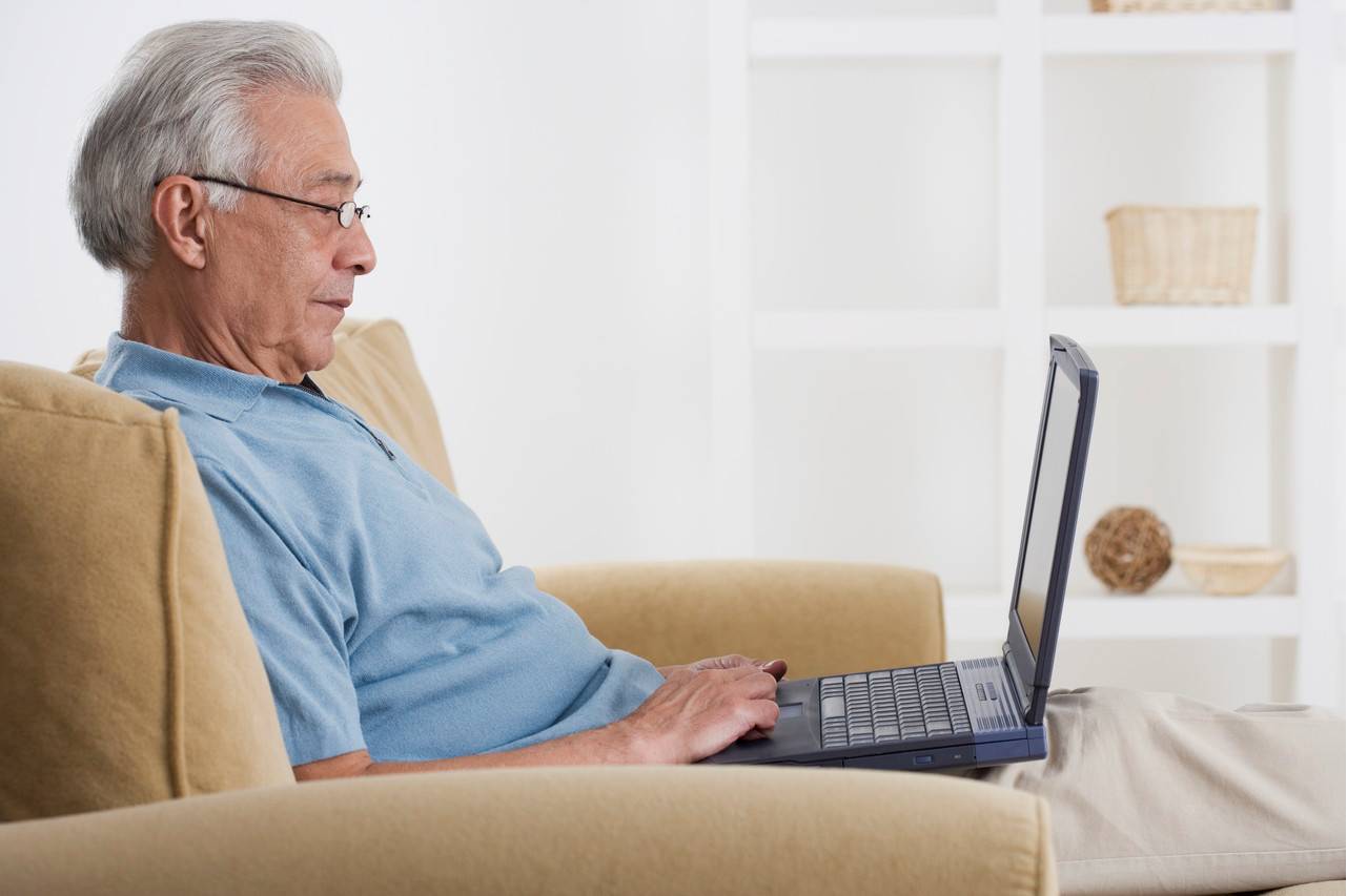 An older adult on a laptop