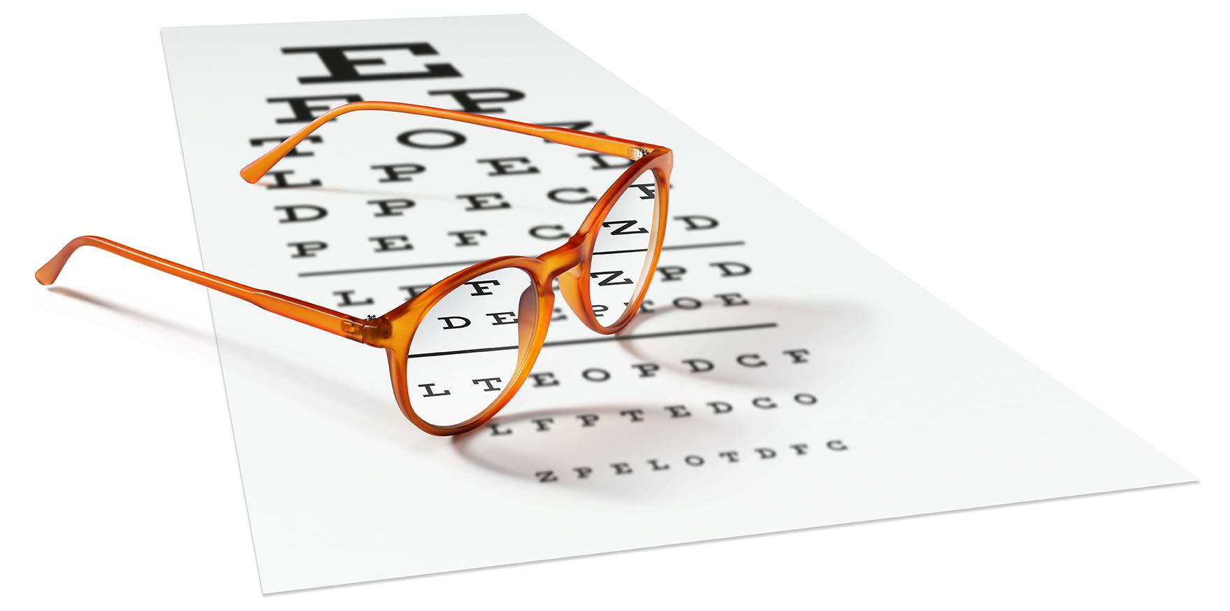 A pair of eyeglasses resting over an eye chart test