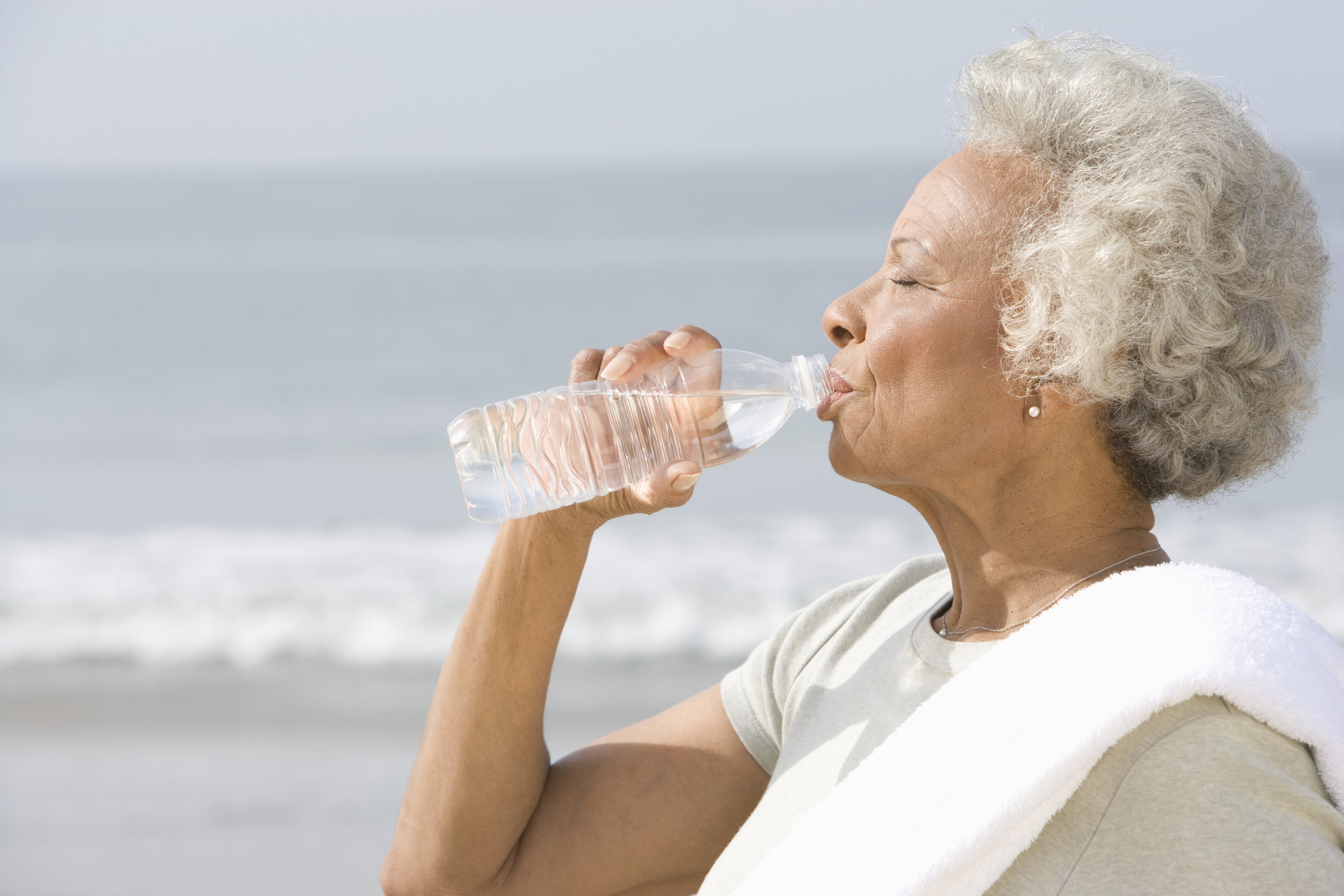 An older adult enjoying a cool drink from a water bottle