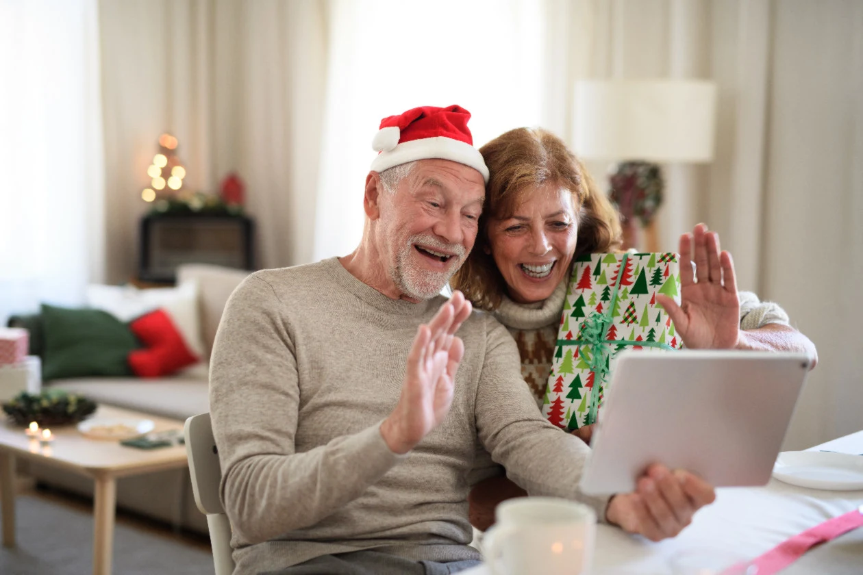 An older couple using a tablet to talk to their family on Christmas