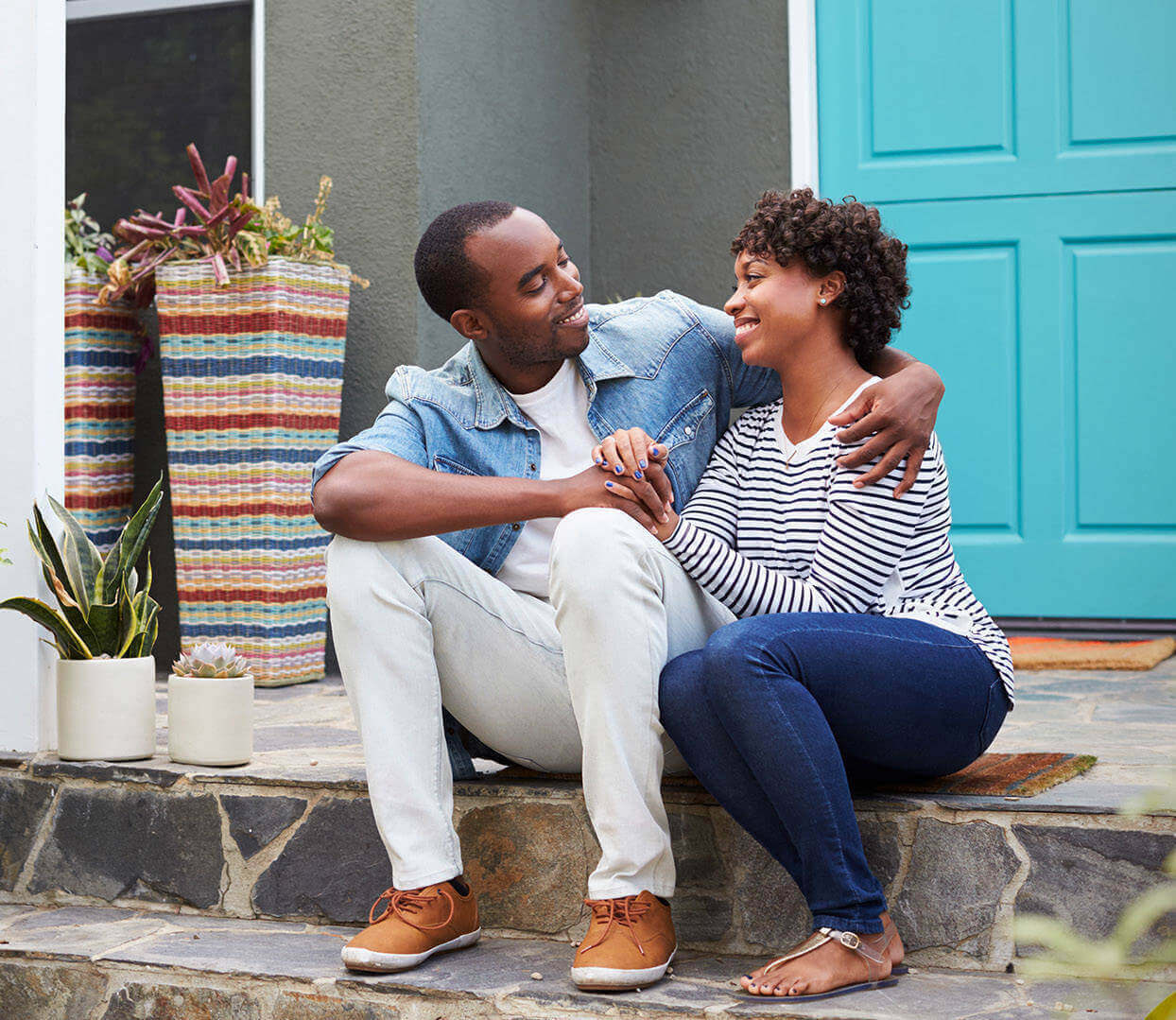 A couple sitting in front of their house