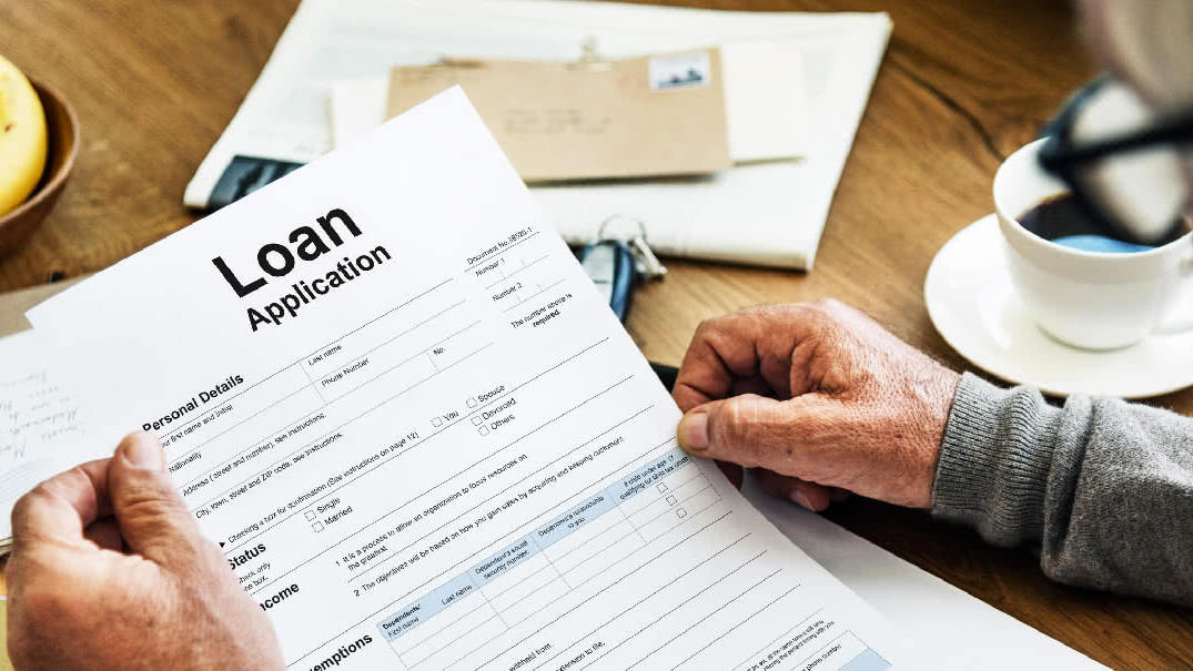 An older adult looking at a loan application