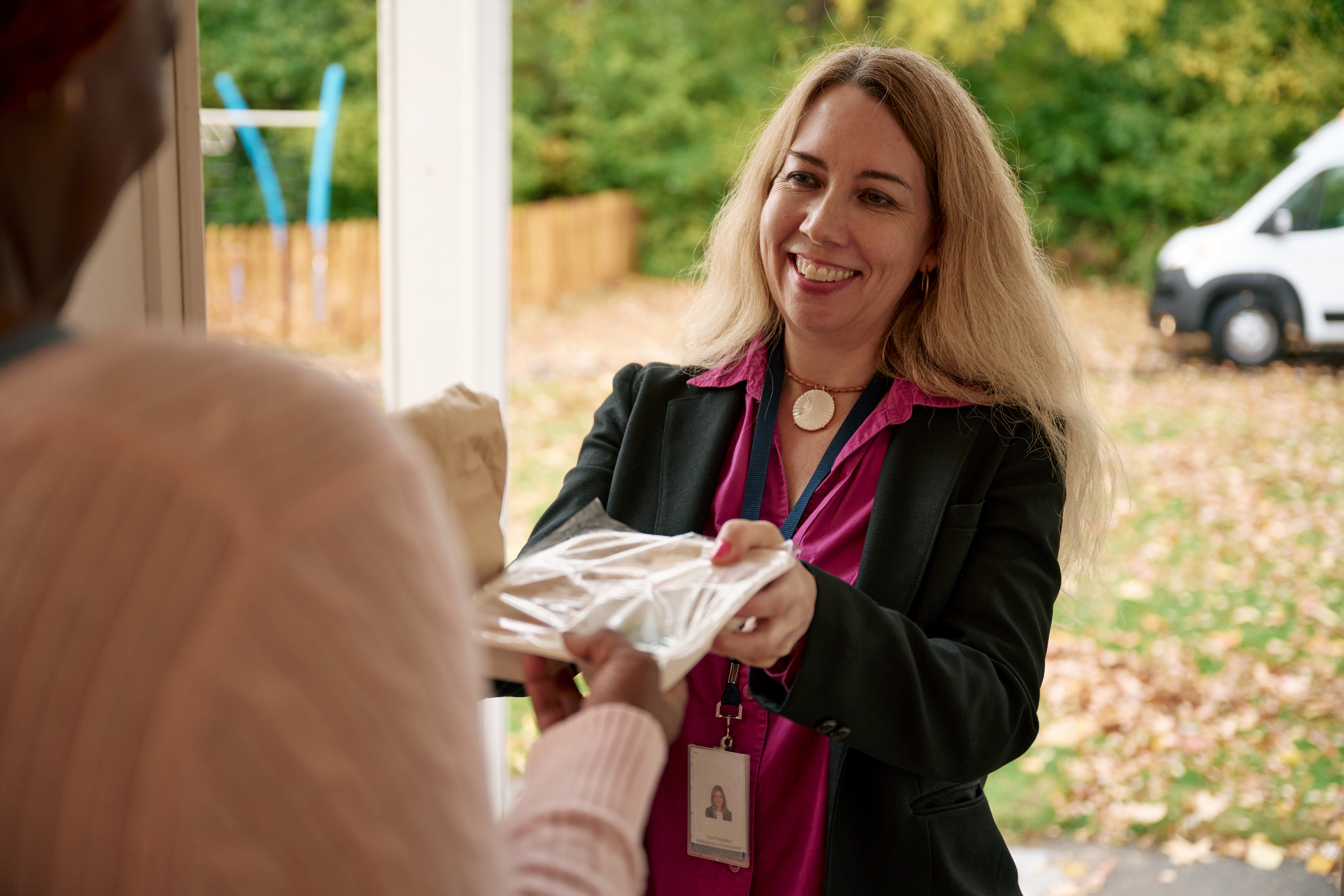 A volunteer delivering a meal to an older adult